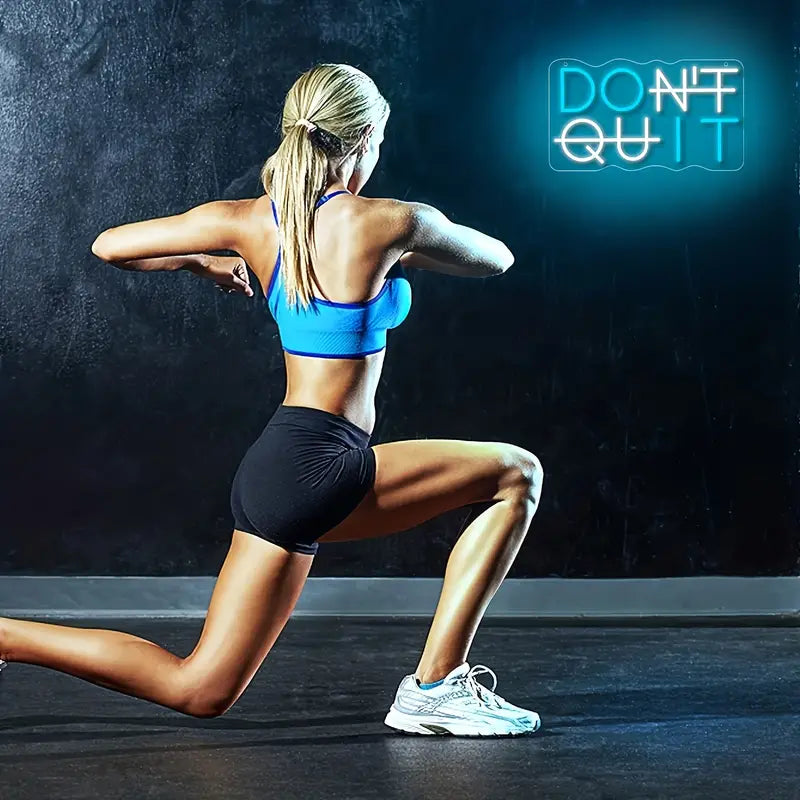 Woman exercising with Don't Quit LED sign