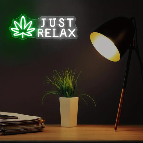 Neon sign 'Just Relax' with leaf, desk lamp, potted plant