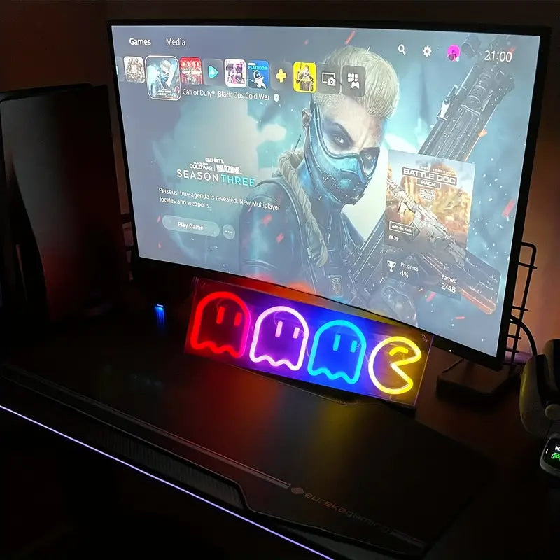 Gaming room setup with Pac-Man neon sign and PS5