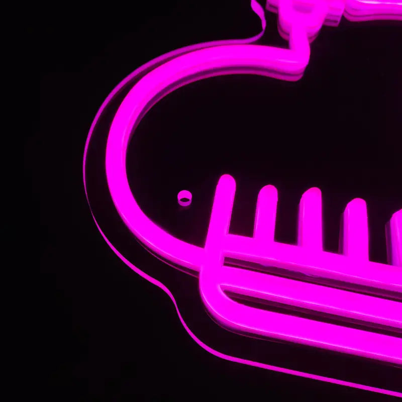 Pink neon barber sign illuminated against a dark backdrop