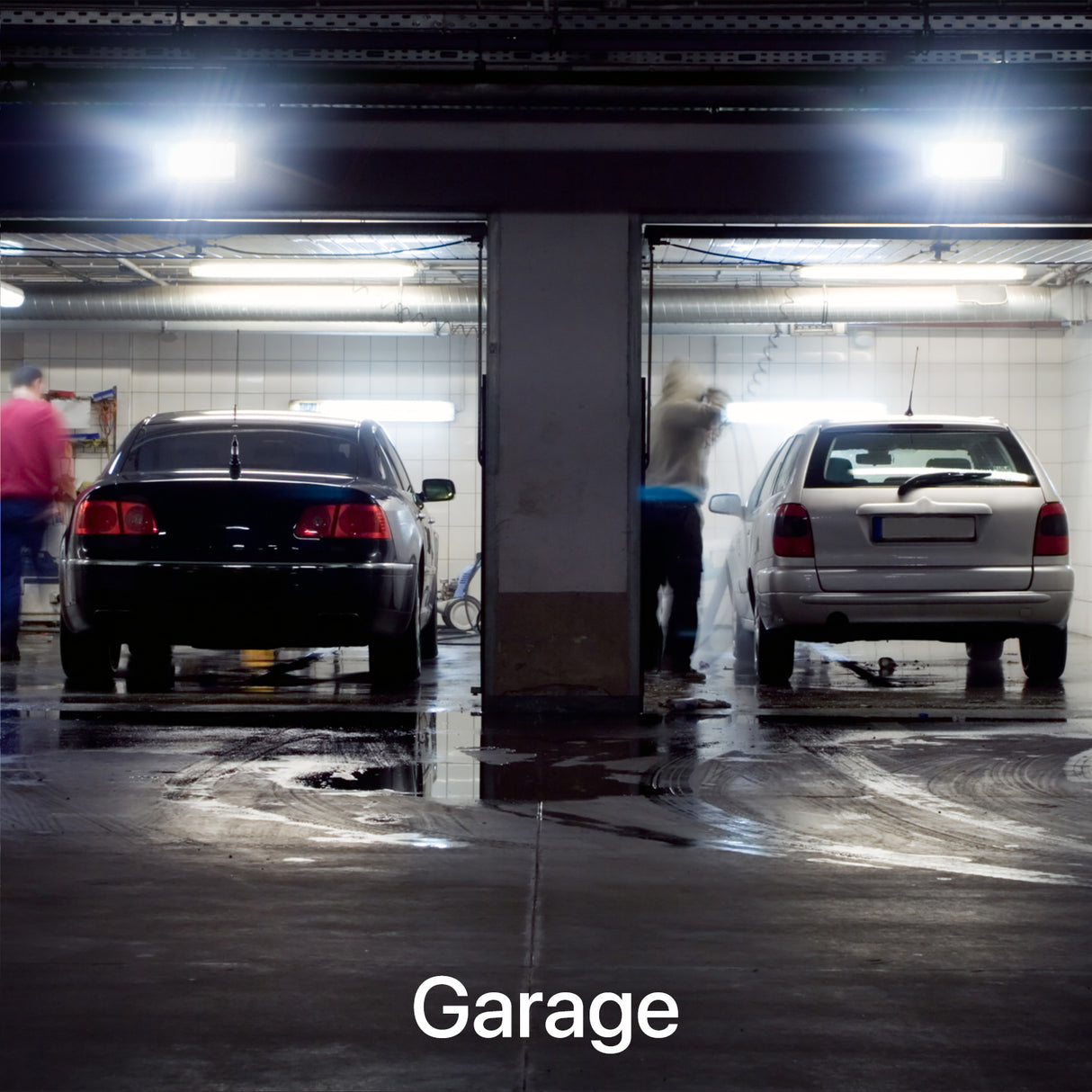 Garage with cars being washed under bright lights