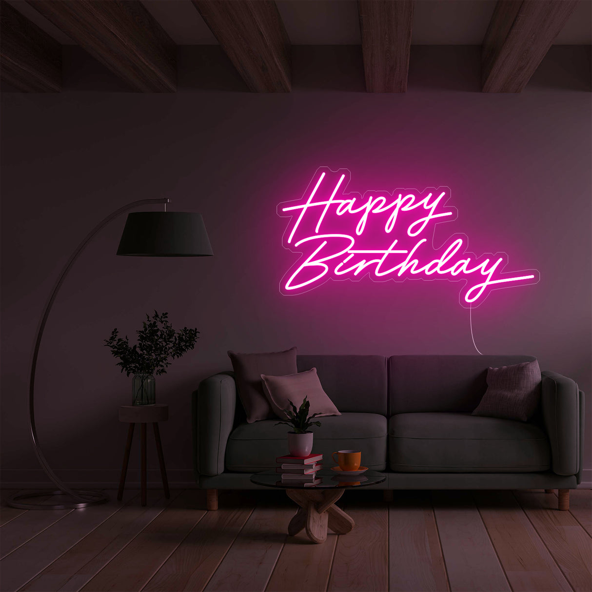 Pink Happy Birthday neon sign over a sofa