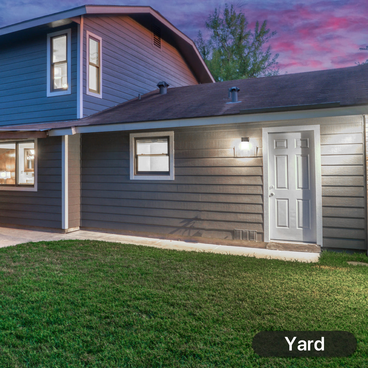Hyperlite LED mini wall pack light installed, illuminating a house yard