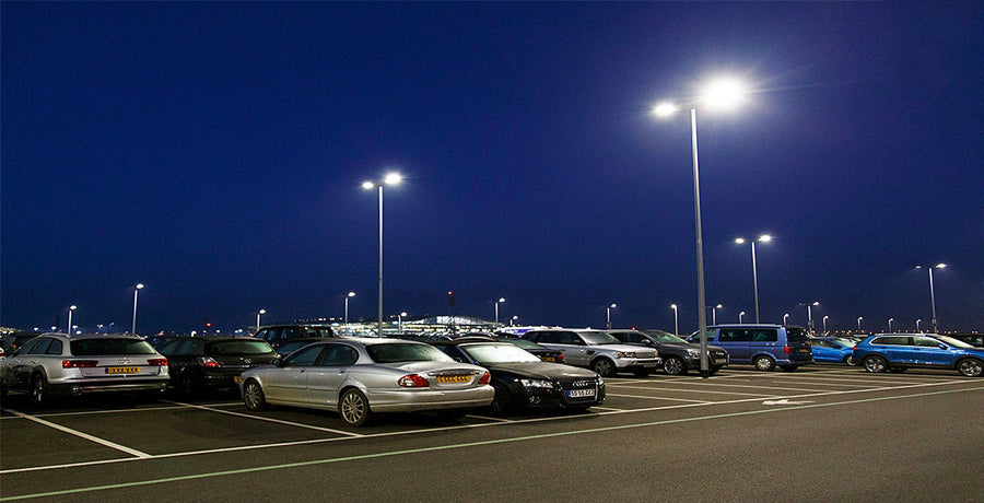 A parking lot full of cars using parking lights