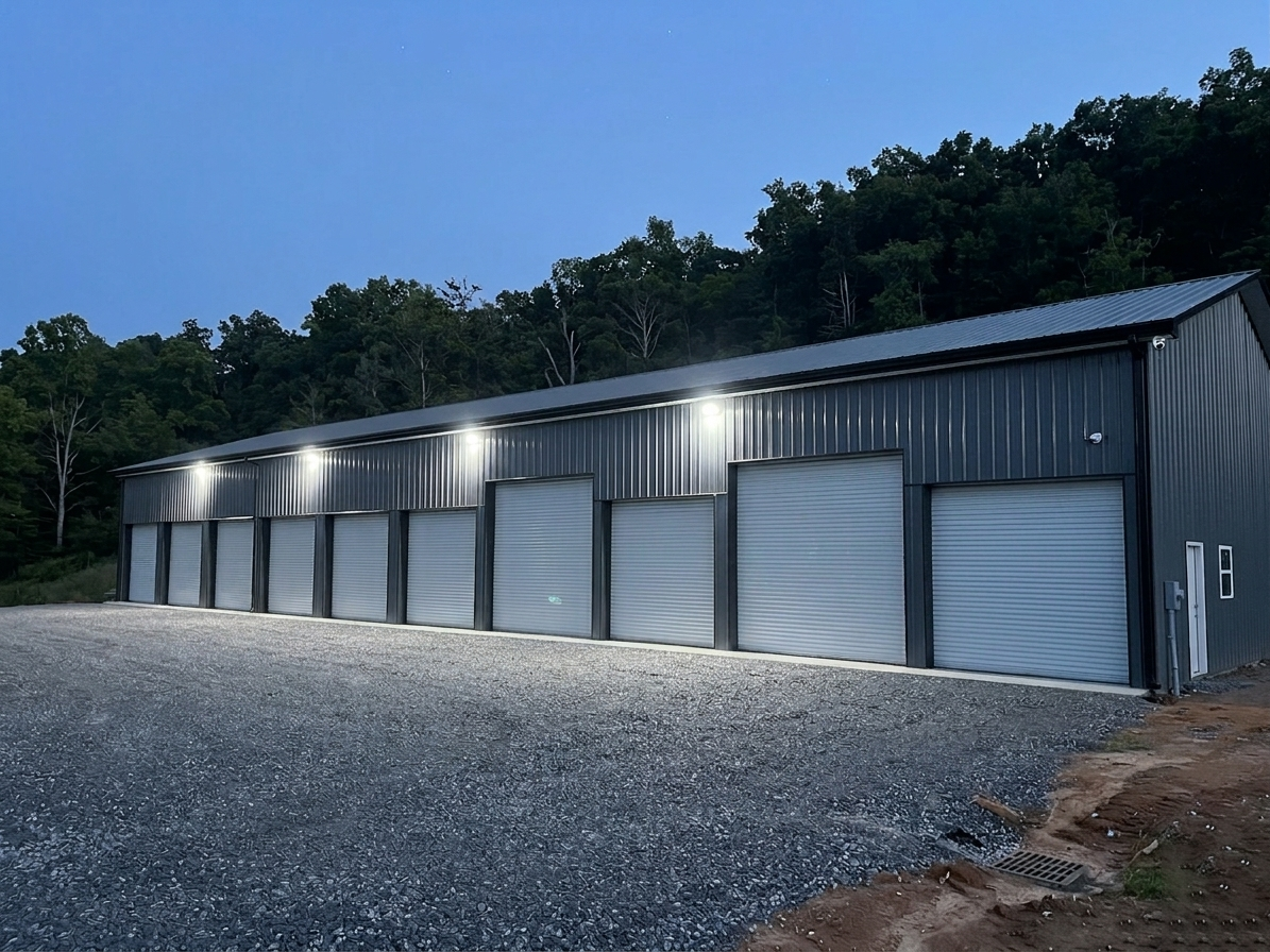 A long commercial metal building illuminated at night by multiple extremely bright 120-watt LED wall packs, demonstrating superior outdoor security and area coverage replacing old HID fixtures.