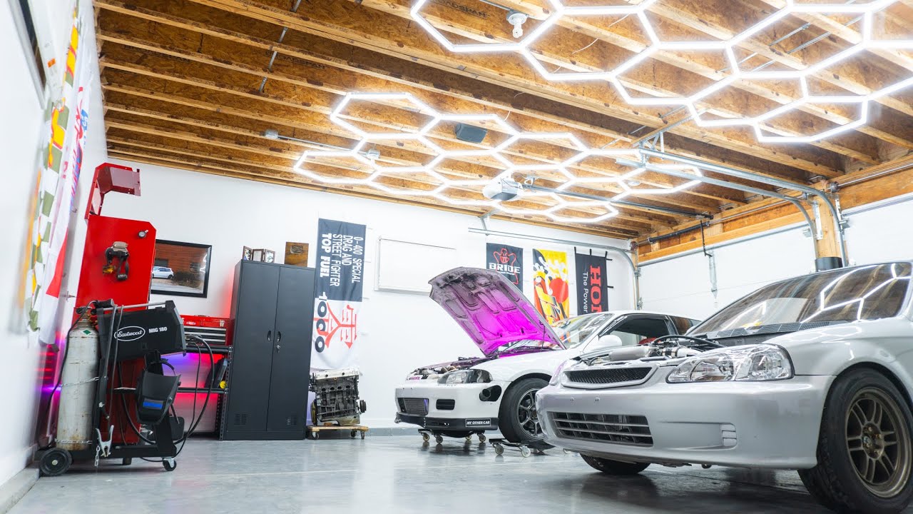 Bright hexagon garage light illuminating an auto garage with cars and wooden ceiling