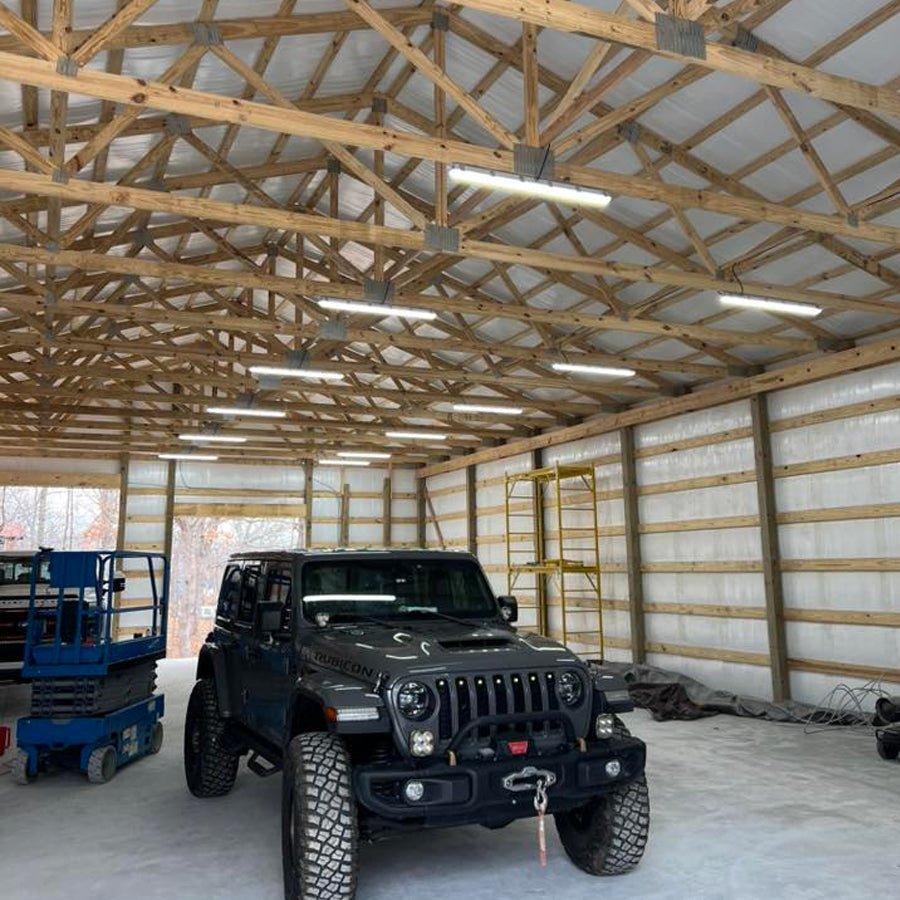 Bright LED high bay lights illuminating a wooden garage with a Jeep Wrangler