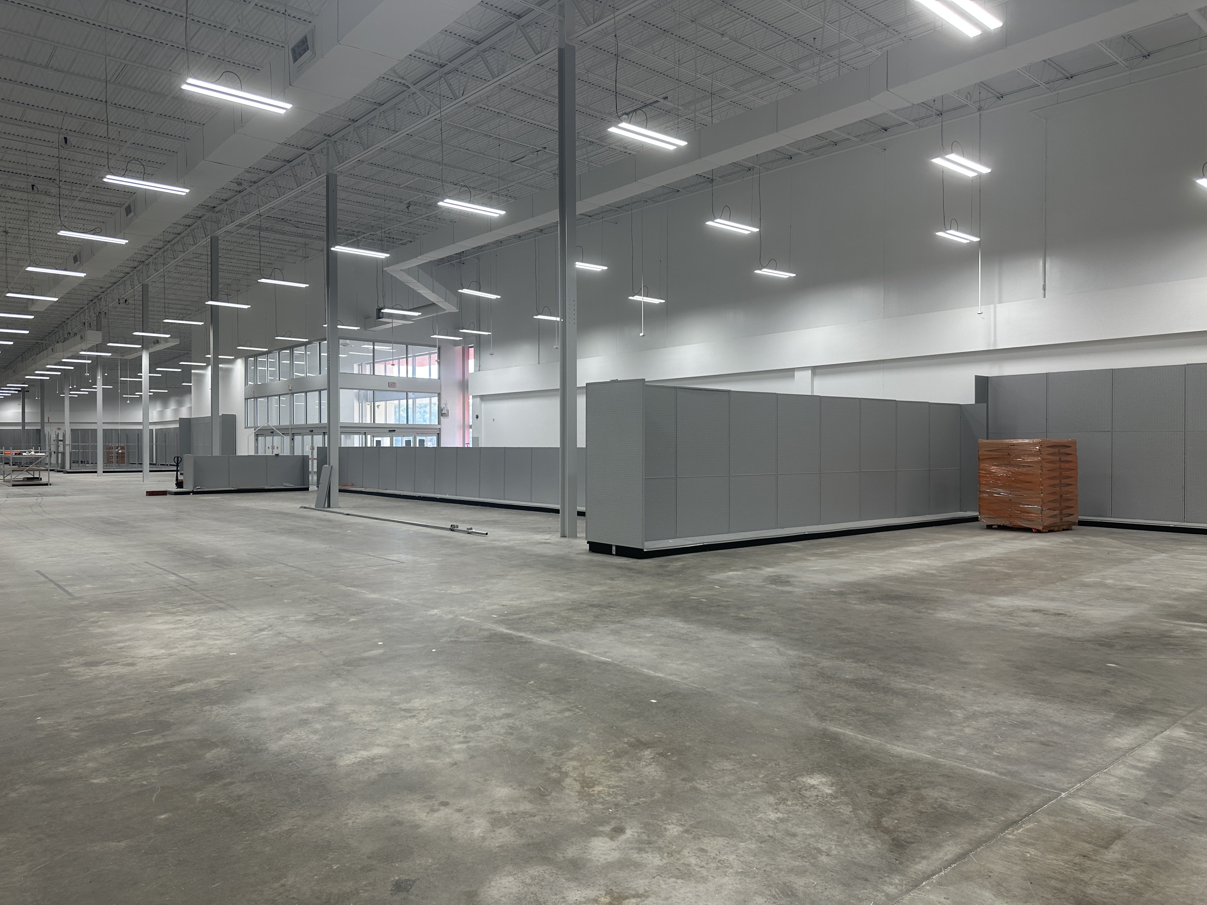 Spacious empty warehouse with suspended high bay light fixtures in a modern industrial interior