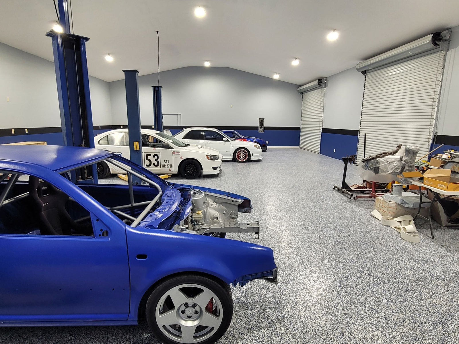 Interior of a spacious garage with high bay LED lights illuminating multiple cars