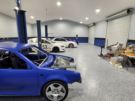 Interior of a spacious garage with high bay LED lights illuminating multiple cars