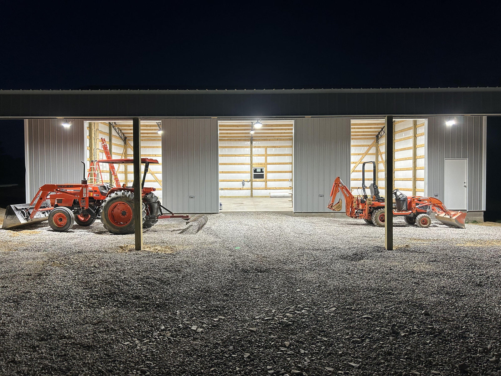 High bay lights are installed in the workshop with two bulldozers at the door.
