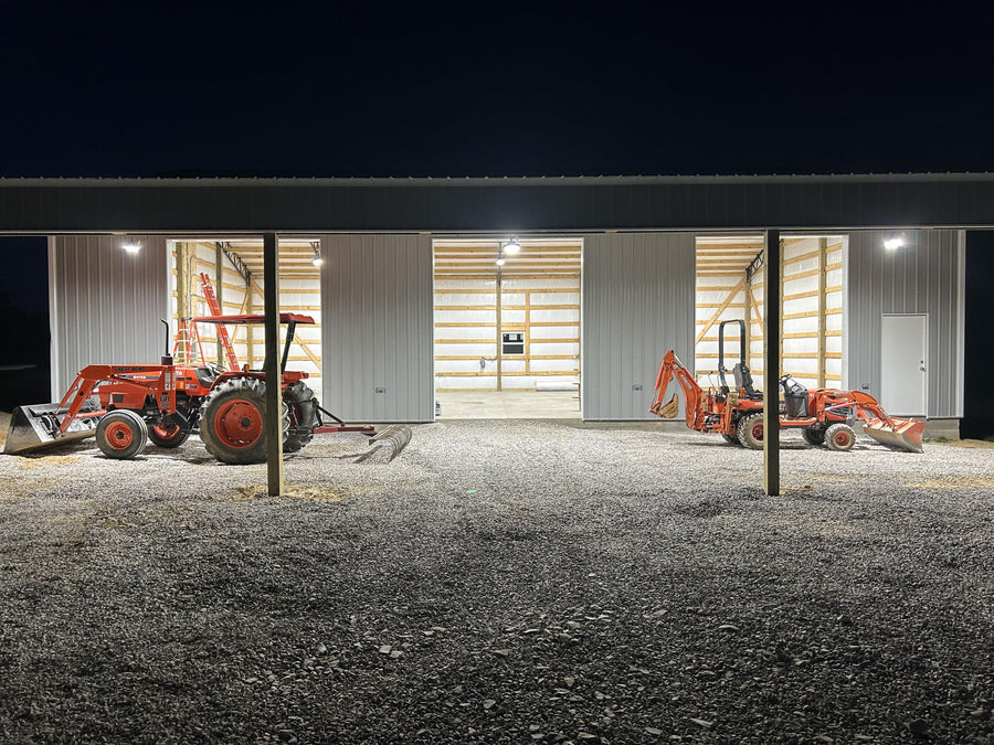 High bay lights are installed in the workshop with two bulldozers at the door.