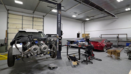 Auto repair shop with cars under LED shop lights