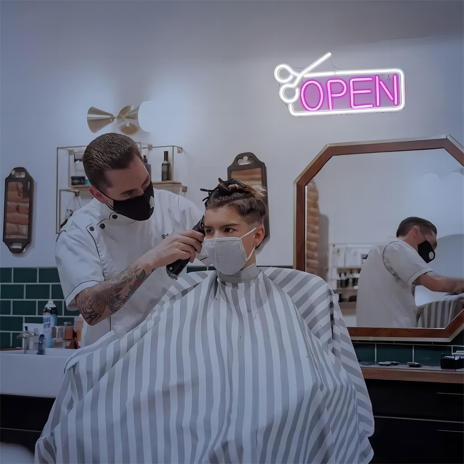 Barber giving haircut under the neon open sign