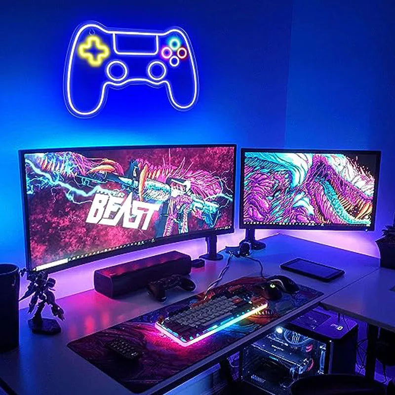 Gaming setup with neon game controller sign and dual monitors