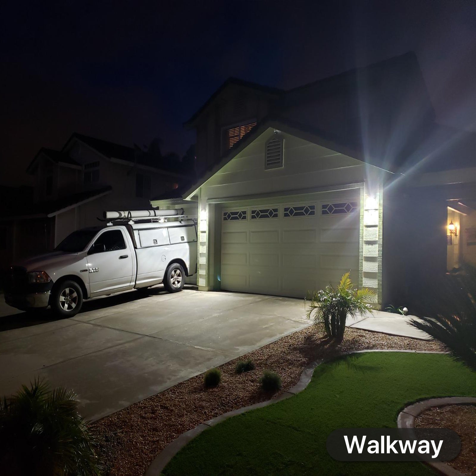 Hyperlite LED wall pack light illuminating driveway and walkway