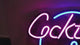 Video of the "Cocktail & Dreams" neon sign lighting up a bar space.